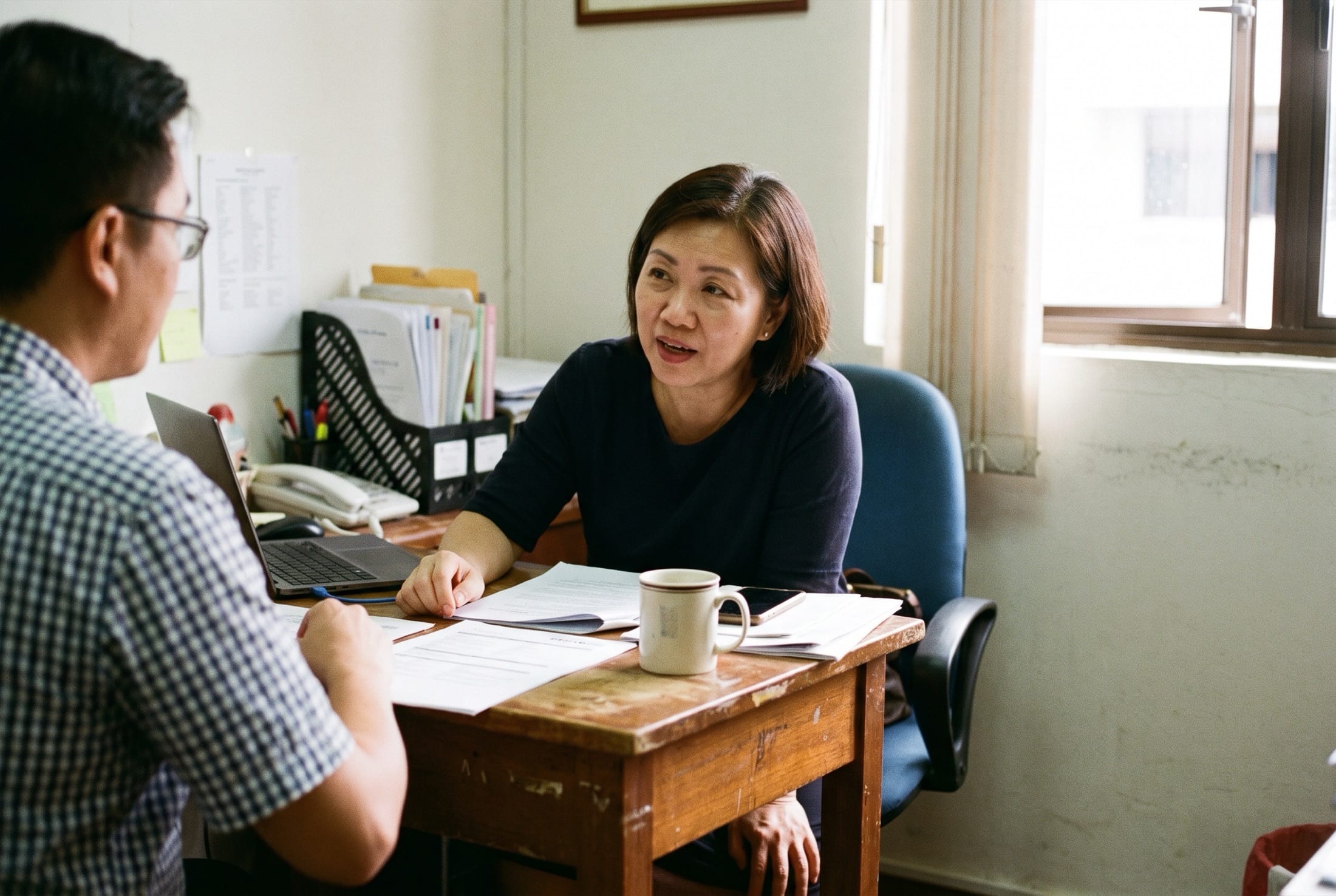 A consultant listening to a candidate across a small table.